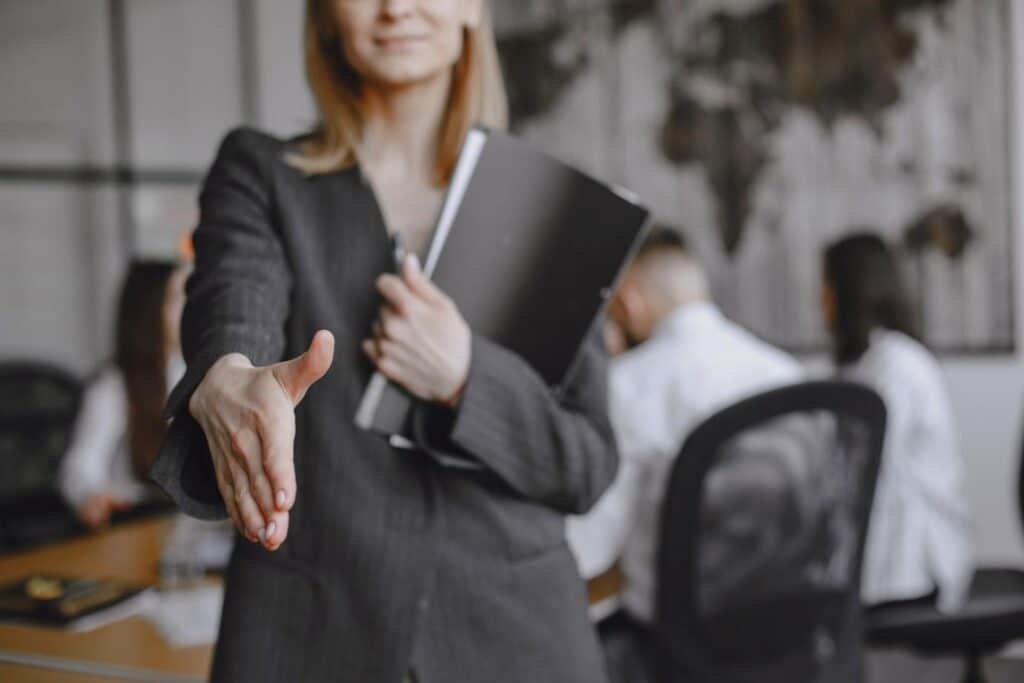 A HR Partner a kezét nyújtja a hatékony toborzási munka megkezdése előtt a megállapodás lezárásaként